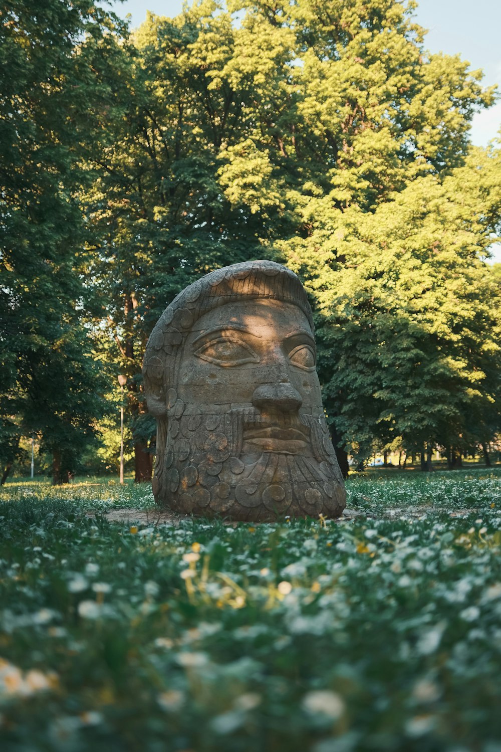 a statue of a man with a beard in a park
