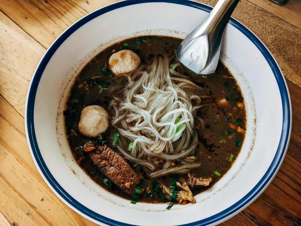 a bowl of soup with noodles, meat and vegetables