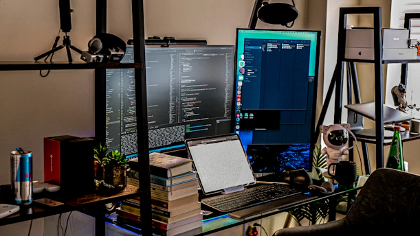 a desk with a computer and a laptop on it