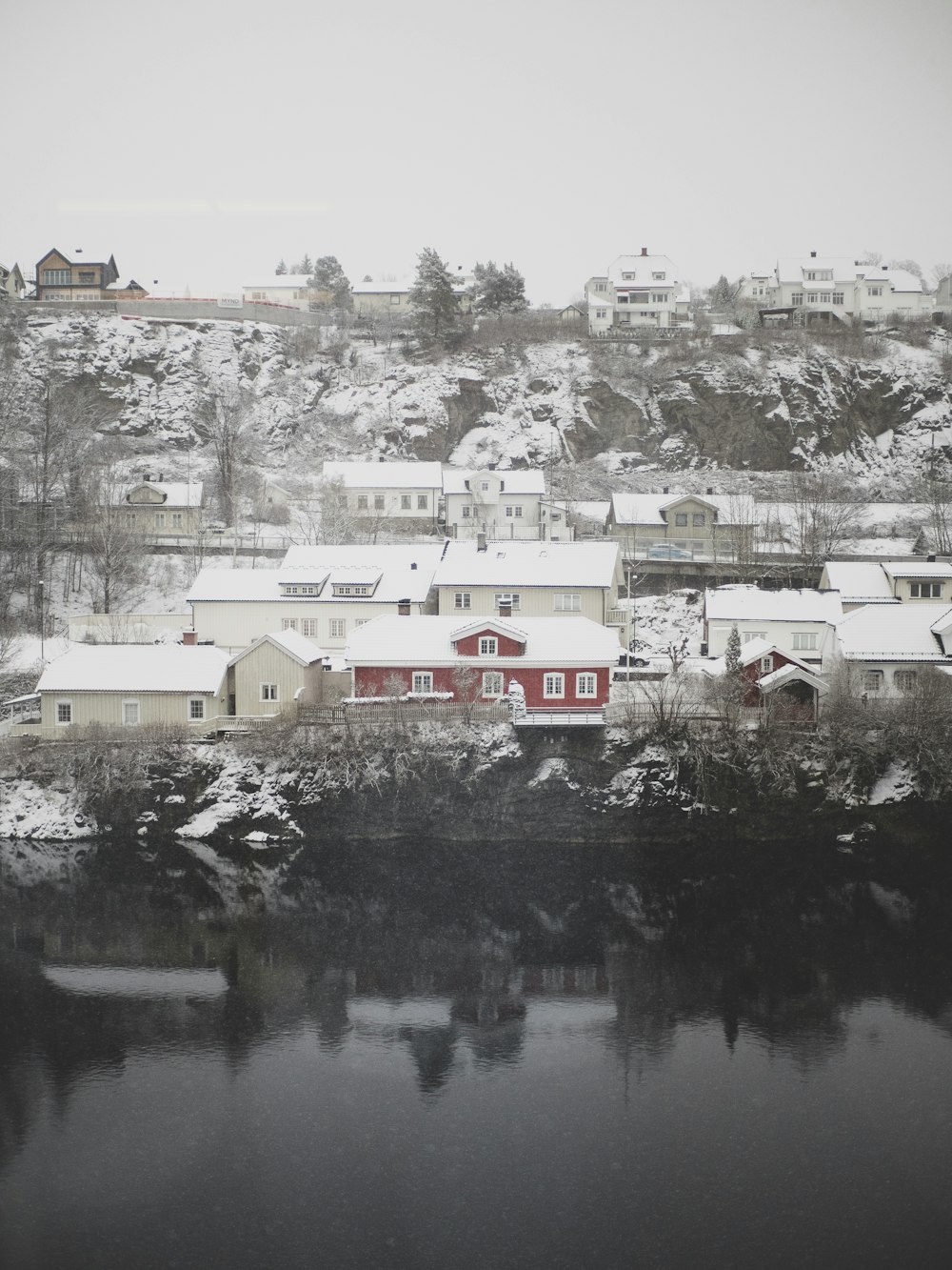 a snowy landscape with houses and a body of water