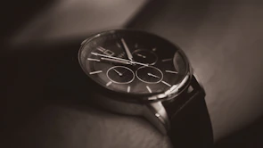 Close-up of a stylish leather watch and bracelet combo on a man’s wrist.