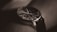 A close-up of a stylish wristwatch on a wooden table.