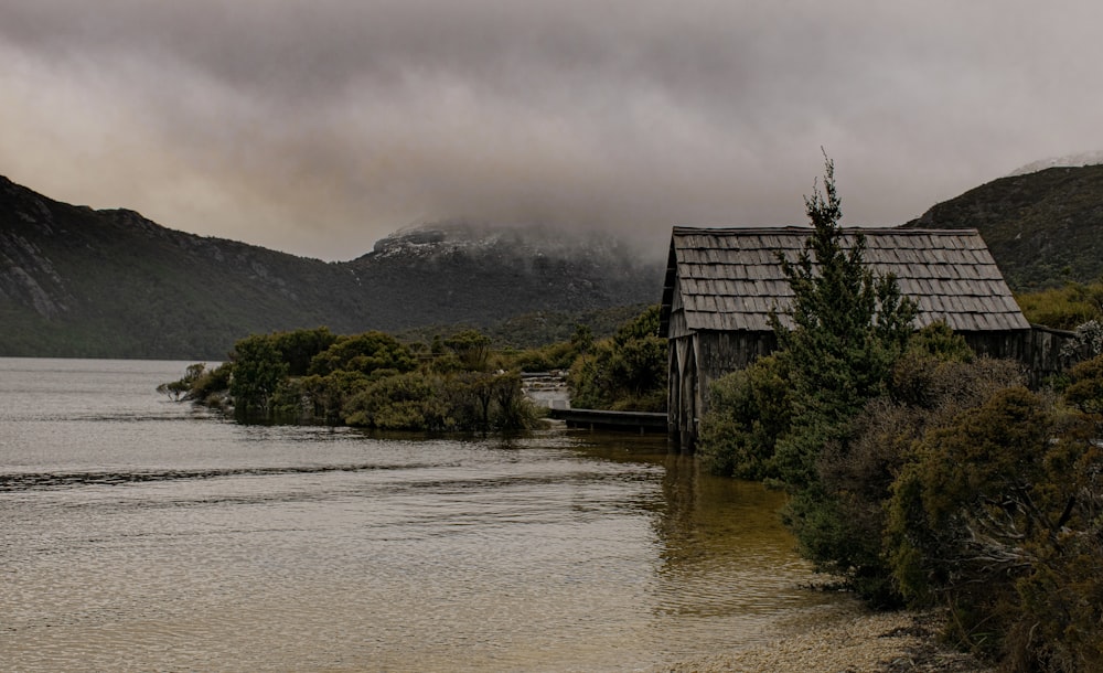 a house sitting on top of a lake next to a forest