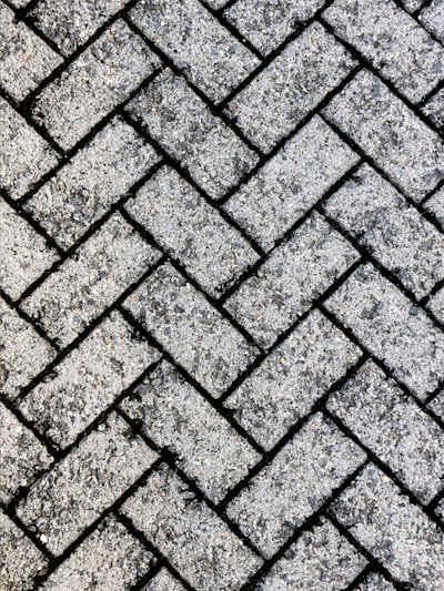 A close-up of freshly laid concrete pavers in a modern driveway under natural daylight.
