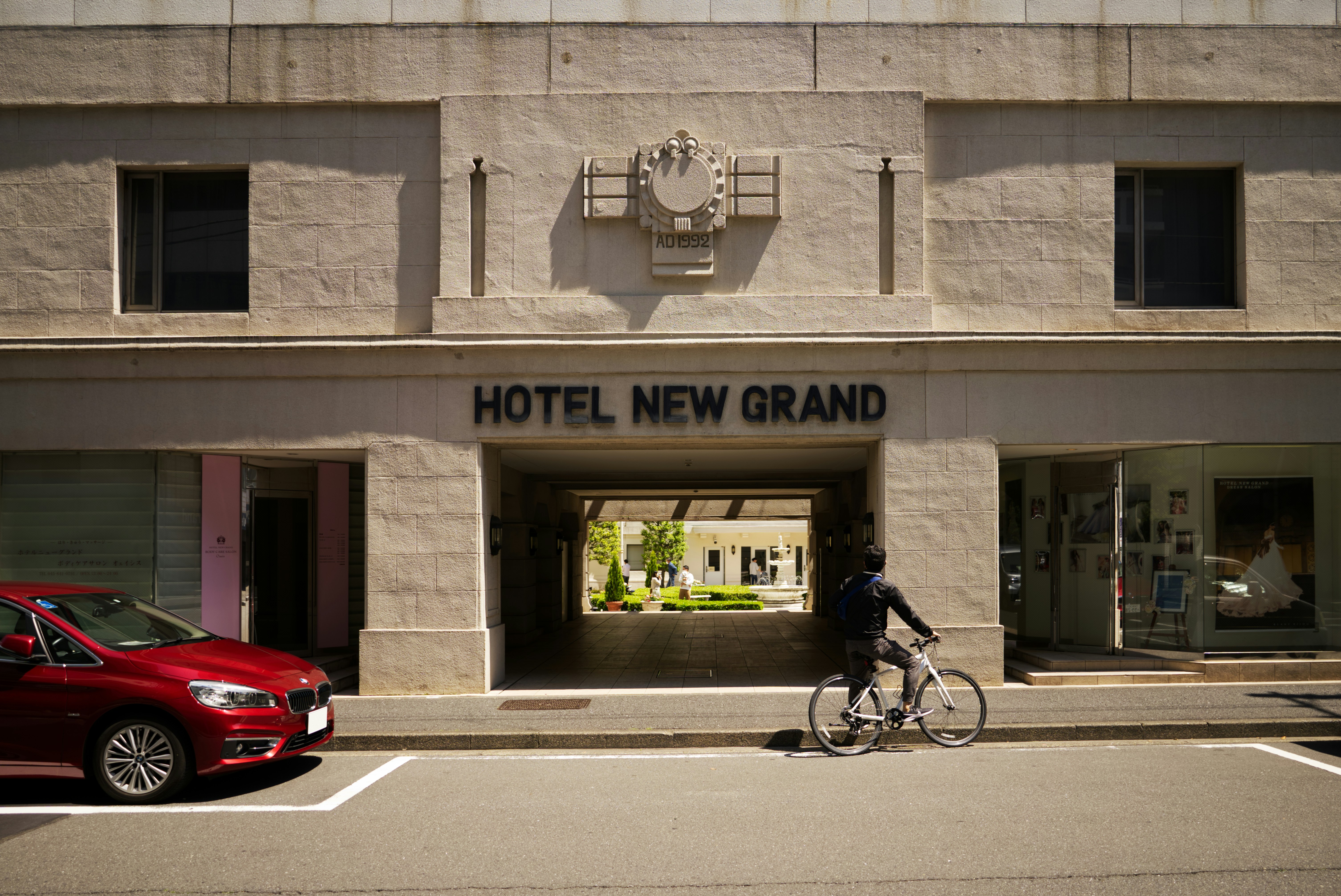 a man riding a bike past a hotel