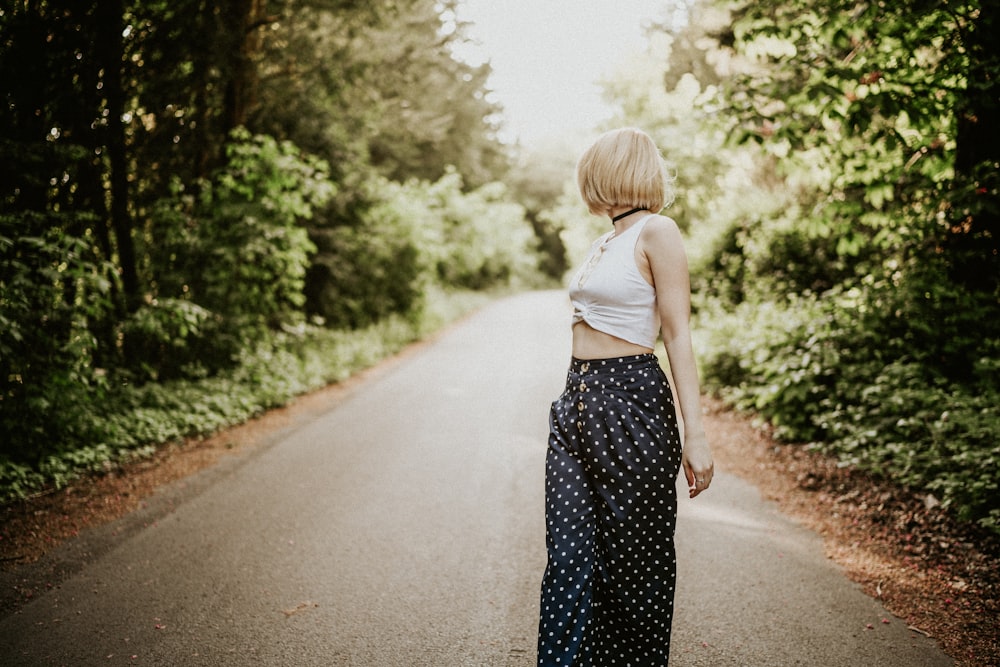 a woman standing in the middle of a road