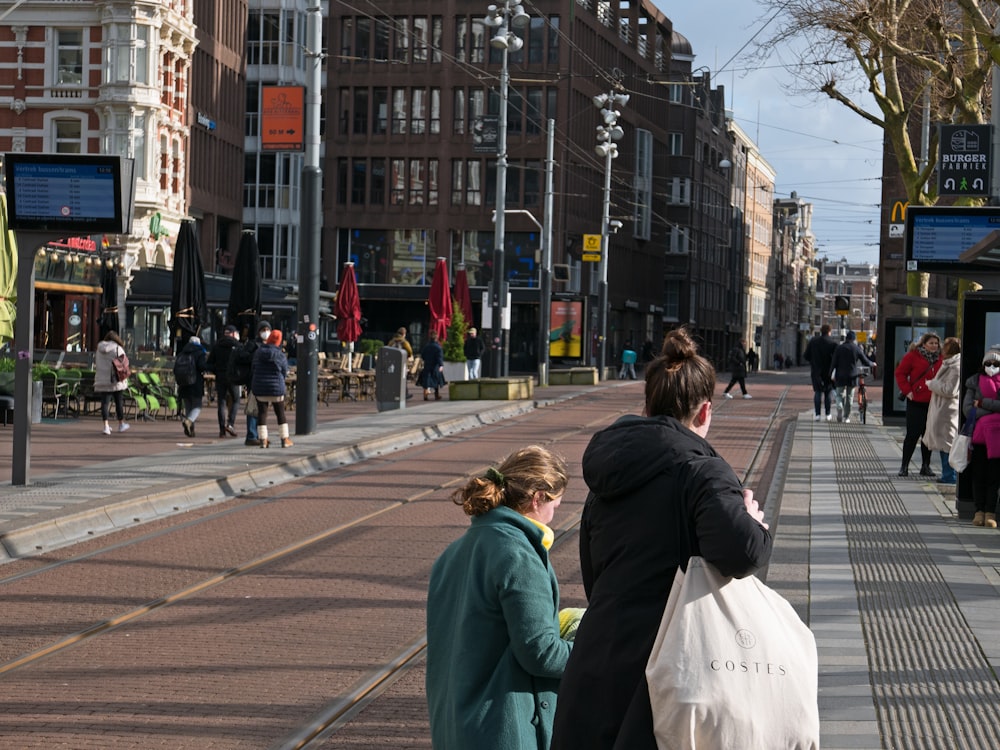 a couple of women standing next to each other on a street