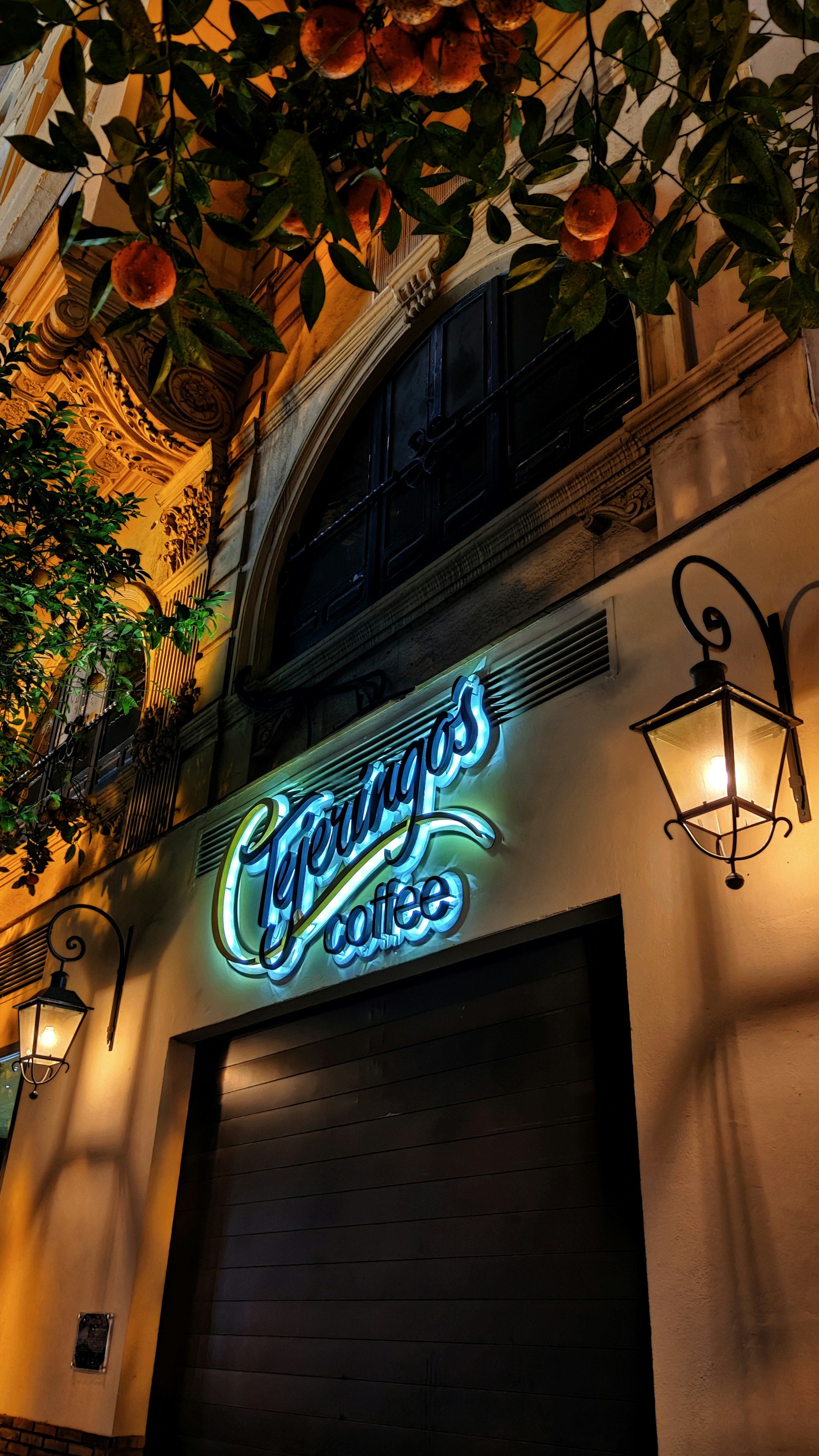 a building with a neon sign and a lamp