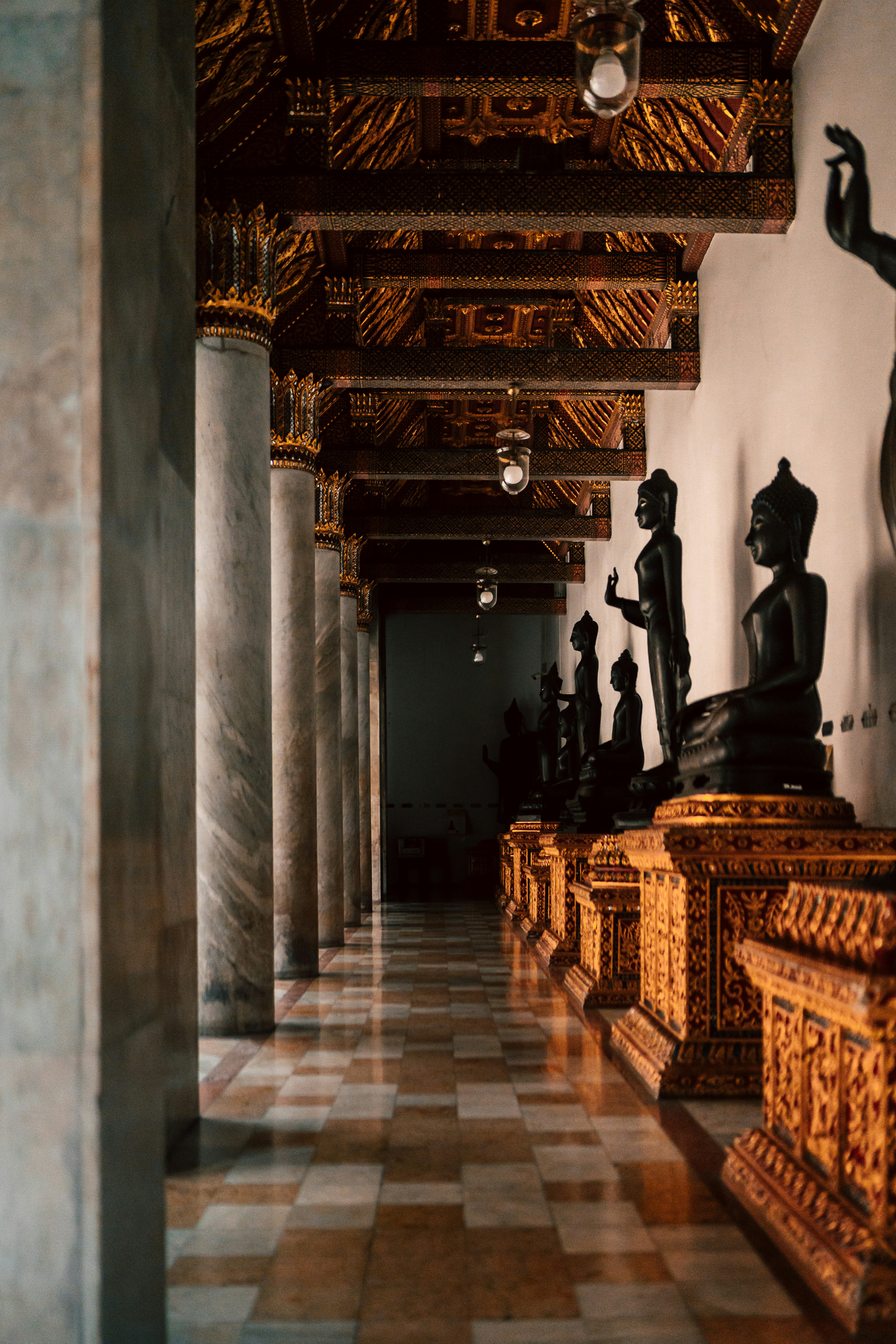 Una hilera de estatuas sentadas encima de un suelo de baldosas