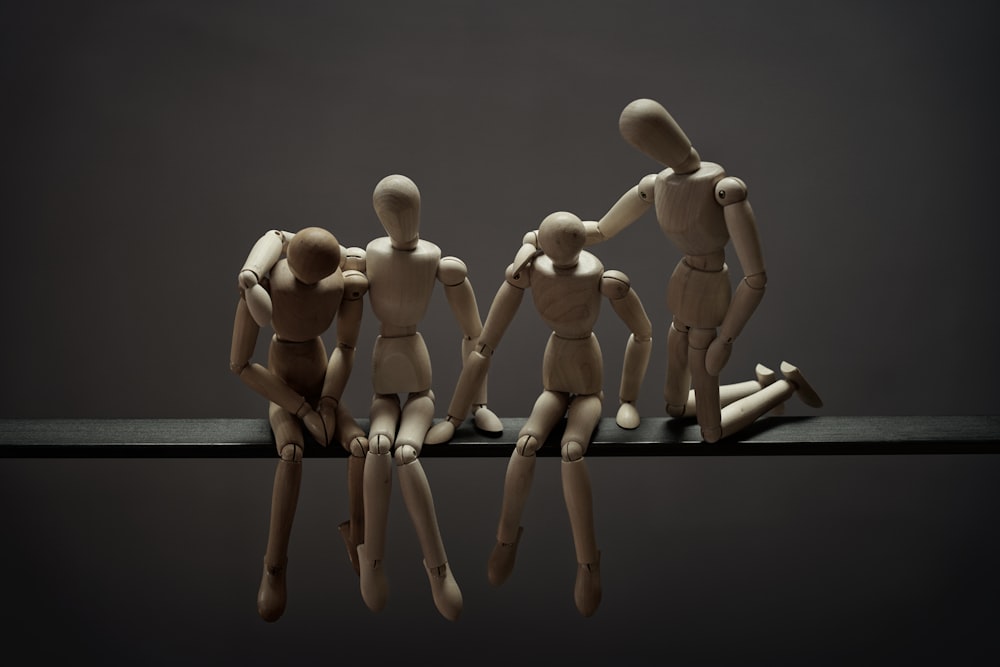 a group of wooden mannequins sitting on top of a table