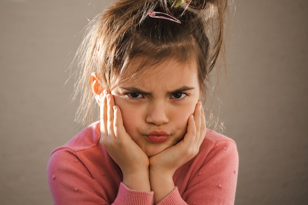 a young girl with her hands on her face