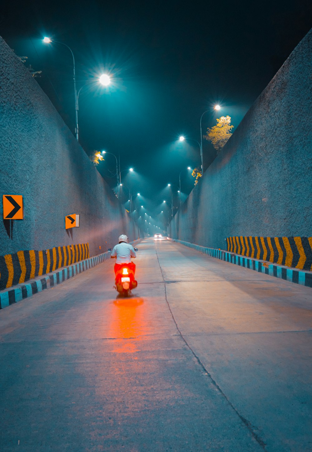 a person riding a motorcycle down a street at night