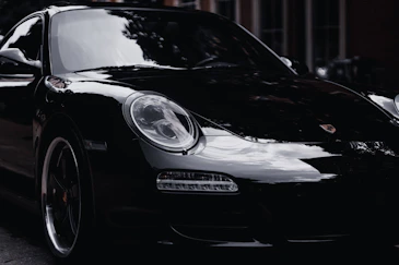 a black porsche parked on the side of the road