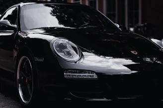 a black porsche parked on the side of the road