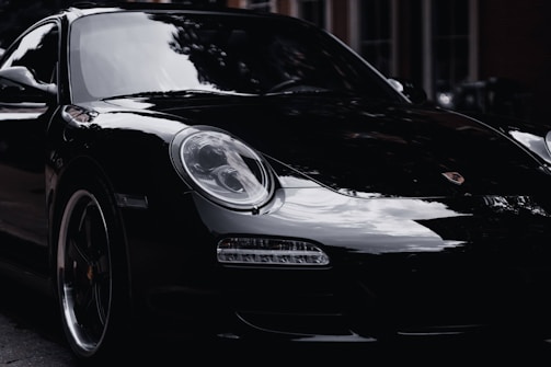 a black porsche parked on the side of the road