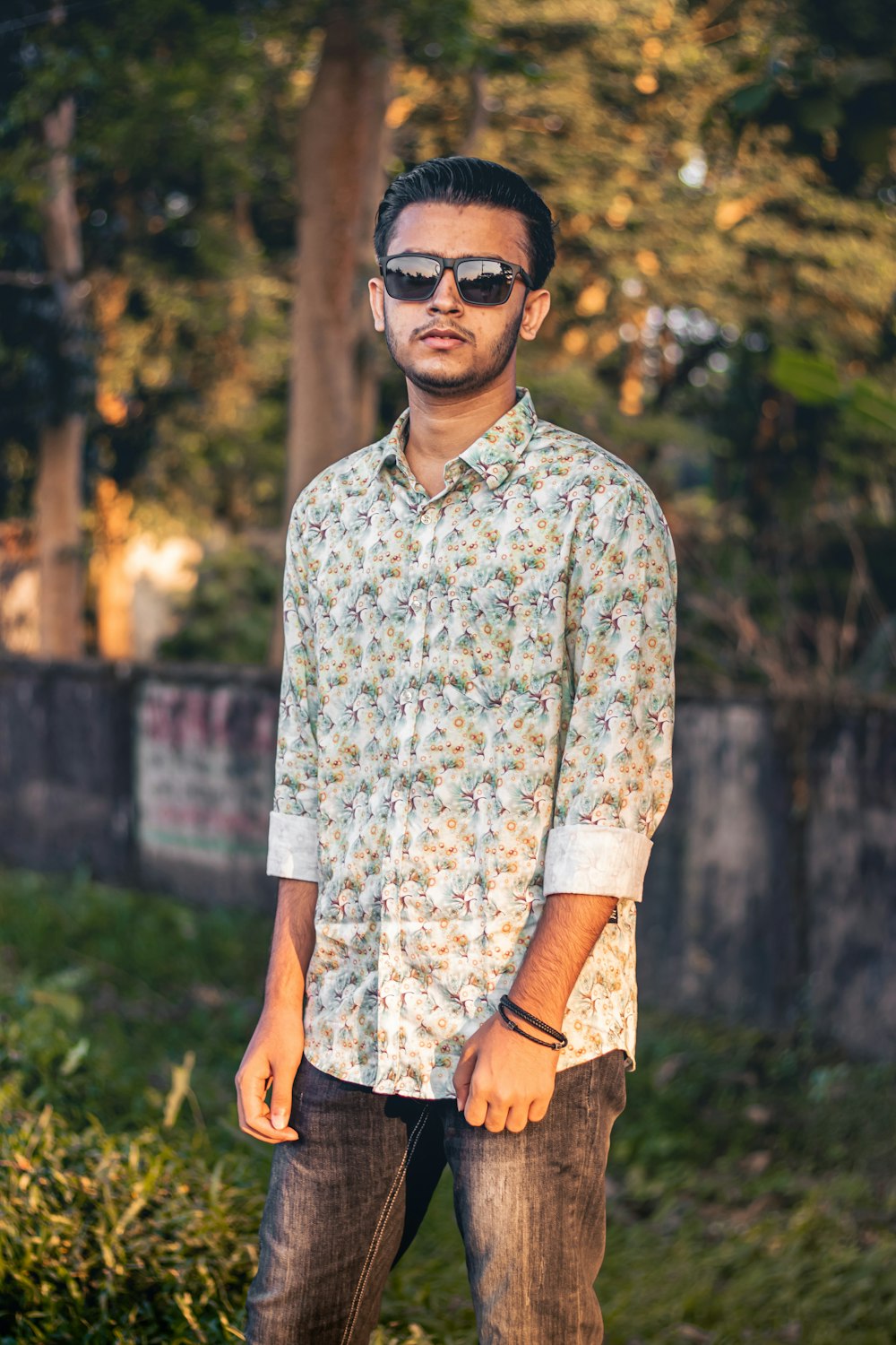 a man wearing sunglasses standing in a field