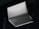 A silver laptop is shown upside down with its lid partially open, revealing the bottom side. The brand name 'Slimbook' is visible on the exterior, with rubber feet and ventilation details on the base. The background is dark, contrasting with the laptop's sleek metallic appearance.