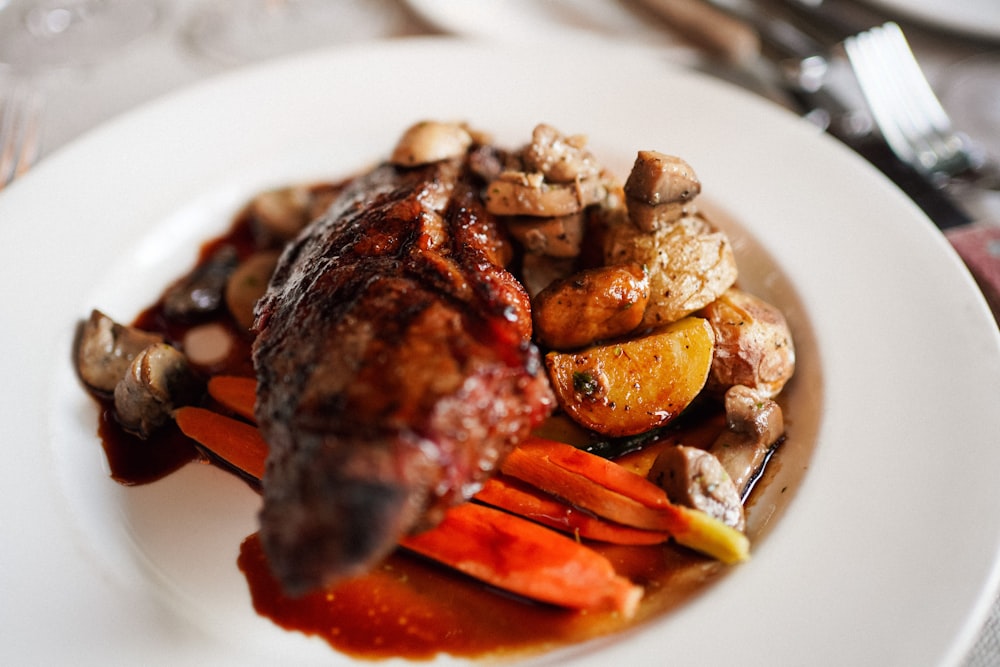 a white plate topped with meat and veggies