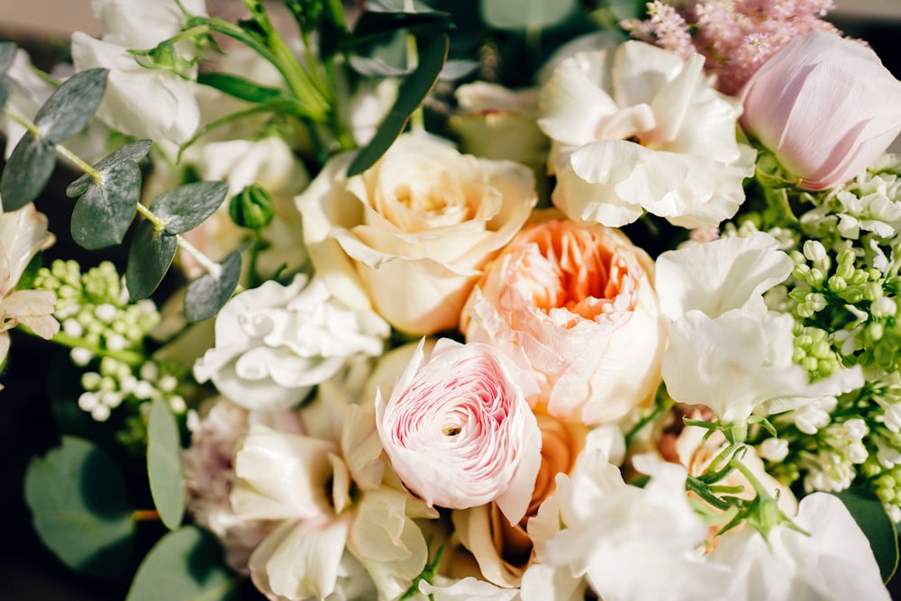 a bouquet of white and pink flowers and greenery