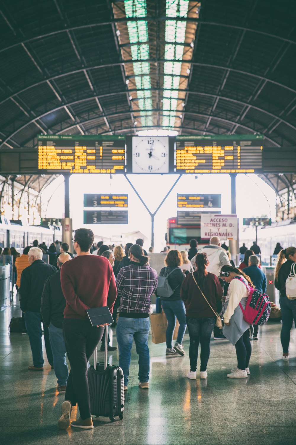 a group of people walking through a train station