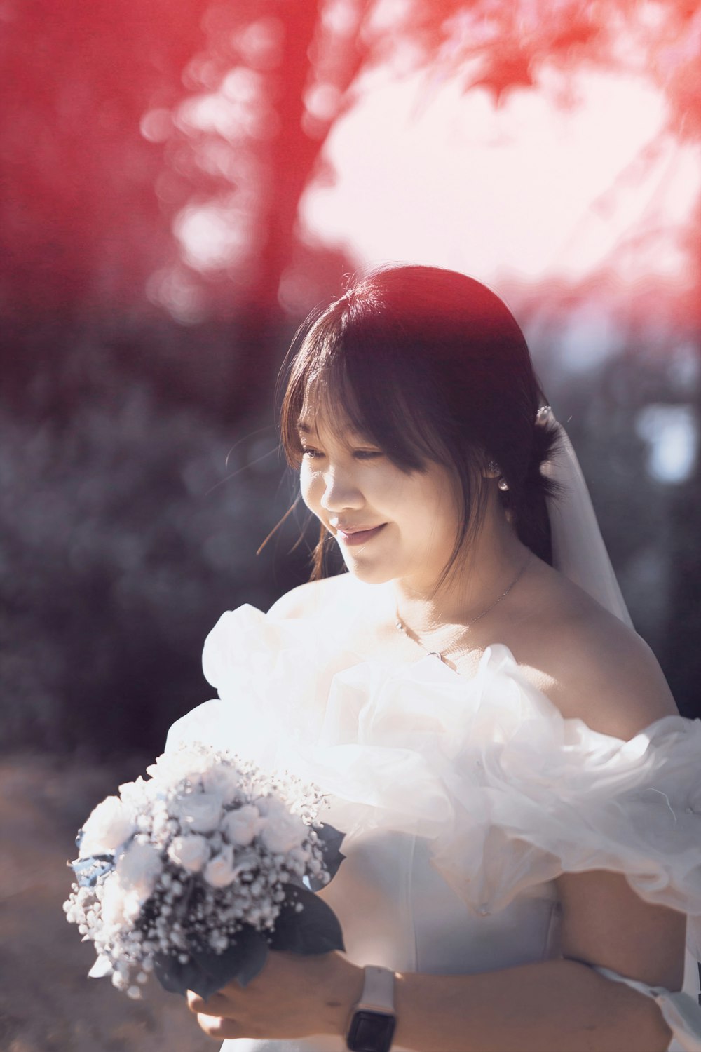 a woman in a wedding dress holding a bouquet of flowers