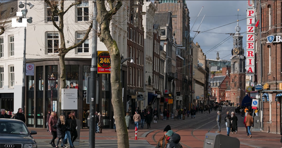 Foto zum Thema Eine Gruppe von Menschen, die eine Straße neben hohen