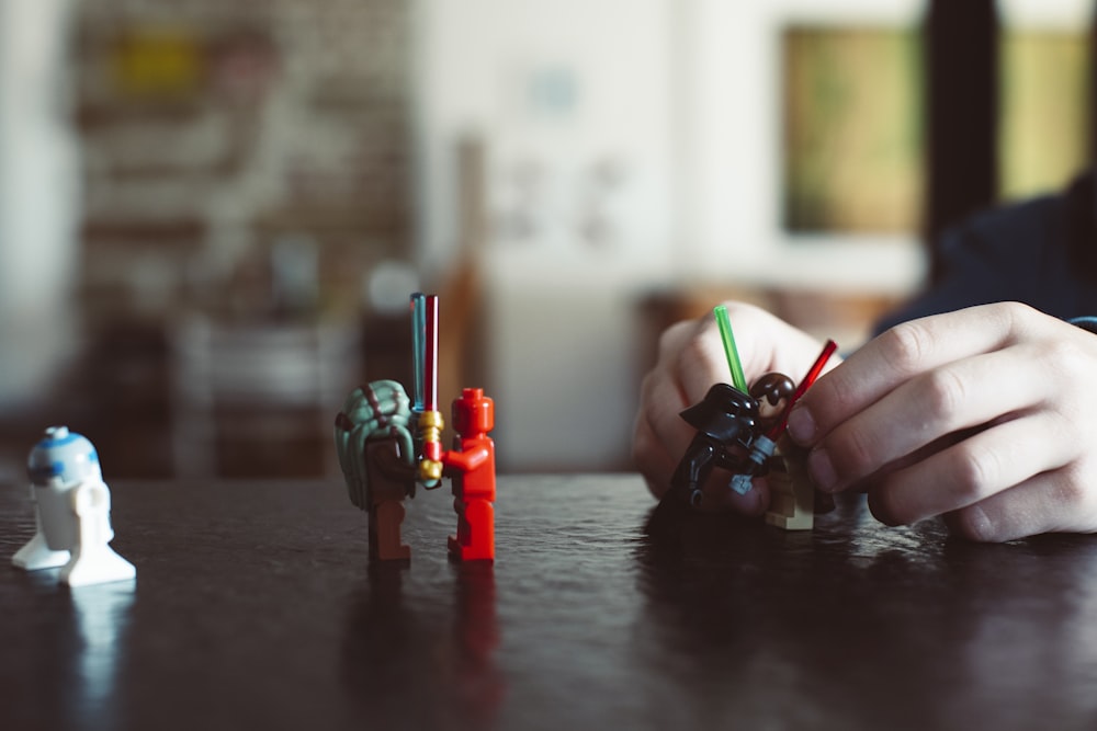 a person sitting at a table playing with legos