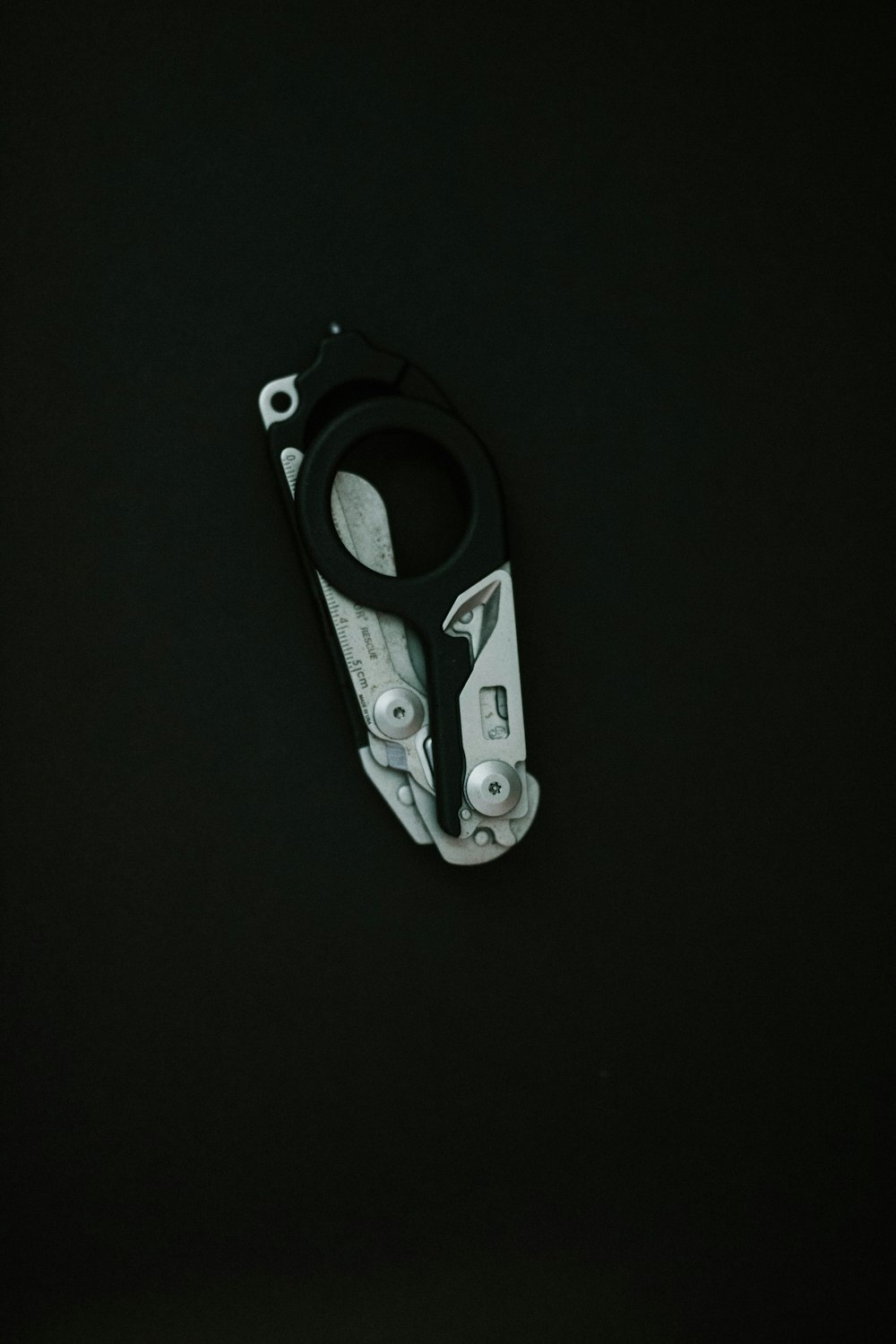 a close up of a pair of scissors on a black surface