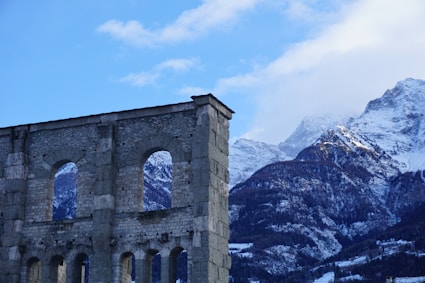 a stone building with a mountain in the background