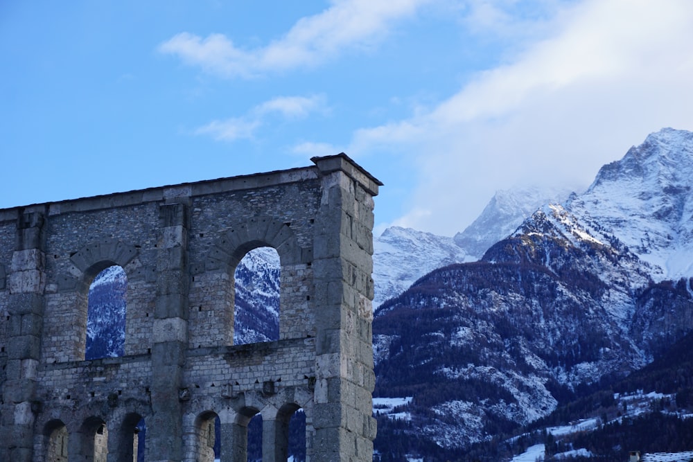 Ein Steingebäude mit einem Berg im Hintergrund