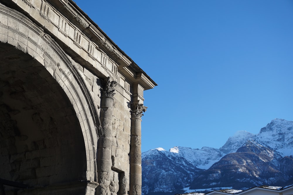 a stone arch with a mountain in the background