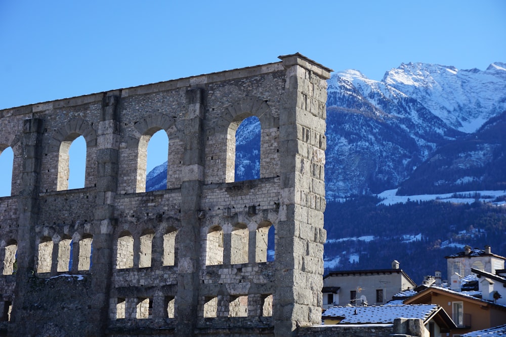 a stone building with a mountain in the background