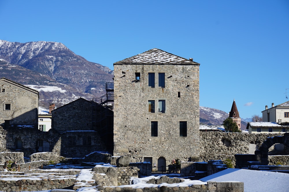 Un edificio in pietra con una montagna sullo sfondo