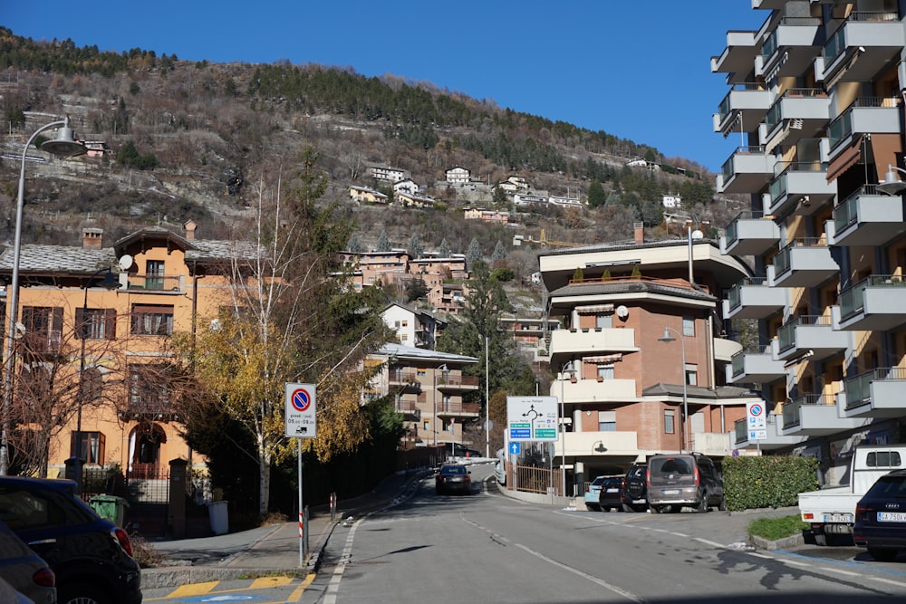 cars parked on the side of the road in front of a mountain