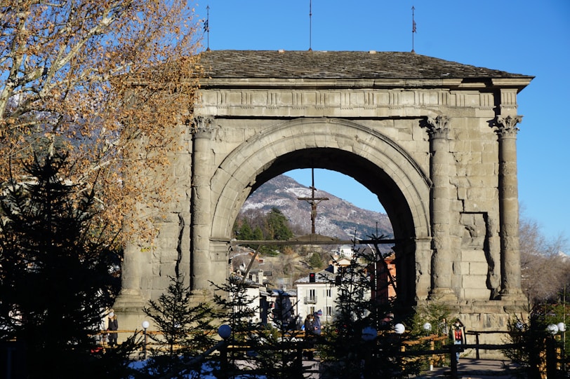 a stone arch with a cross on top of it