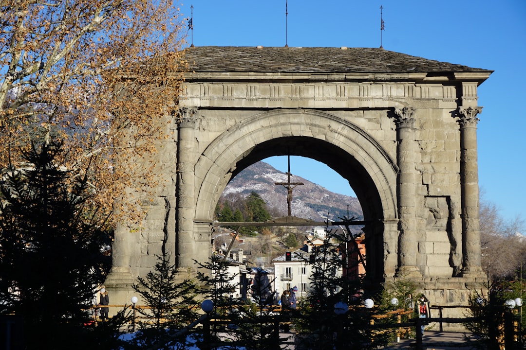 a stone arch with a cross on top of it,