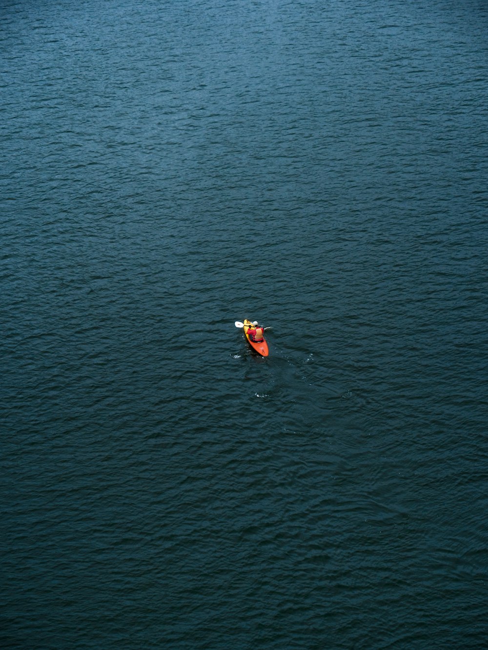 a person in a kayak in the middle of a body of water