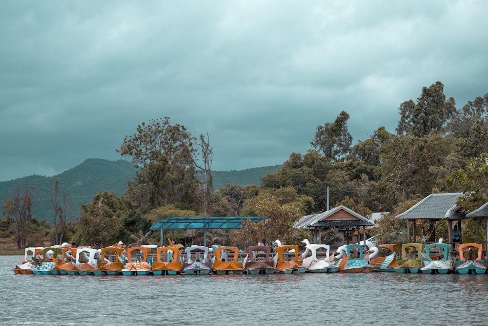 a row of colorful boats floating on top of a lake