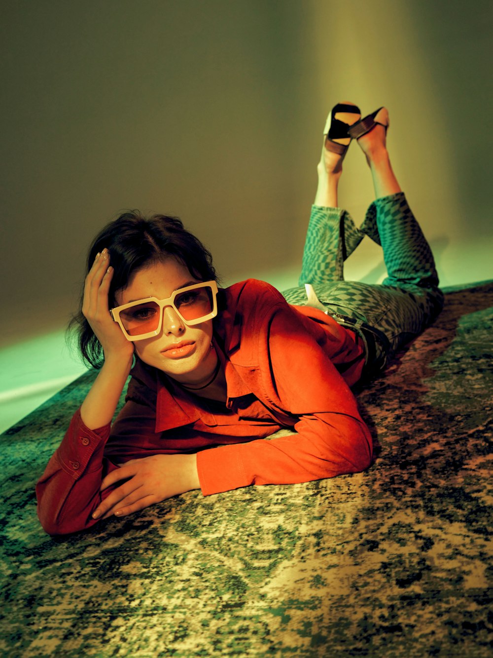 a woman laying on the ground wearing sunglasses