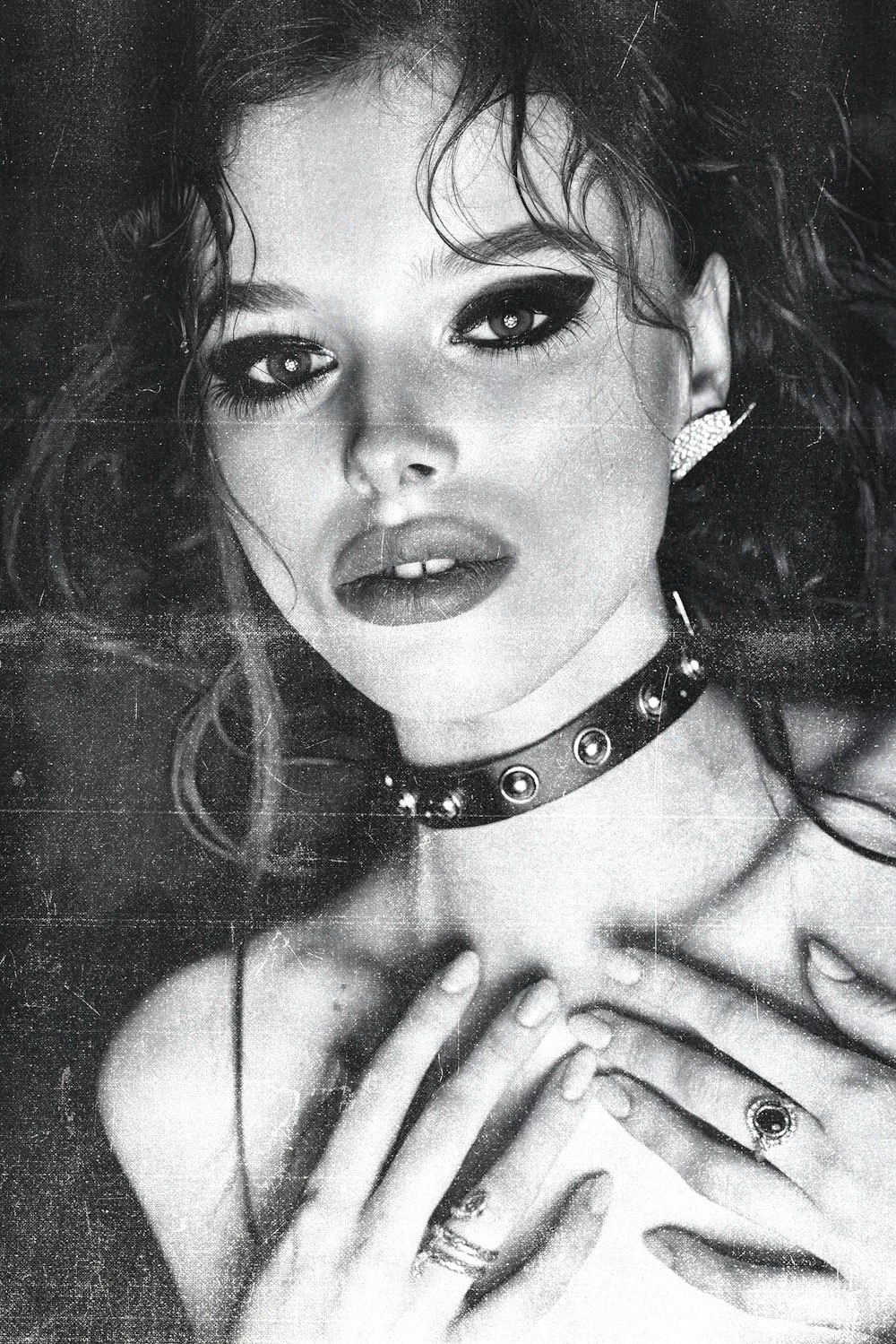 a black and white photo of a woman wearing a choker