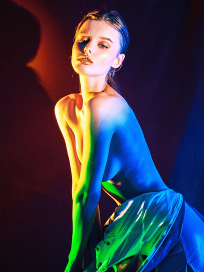 a woman in a blue and green dress posing for a picture