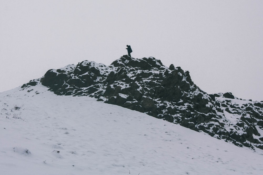 a person standing on top of a snow covered mountain