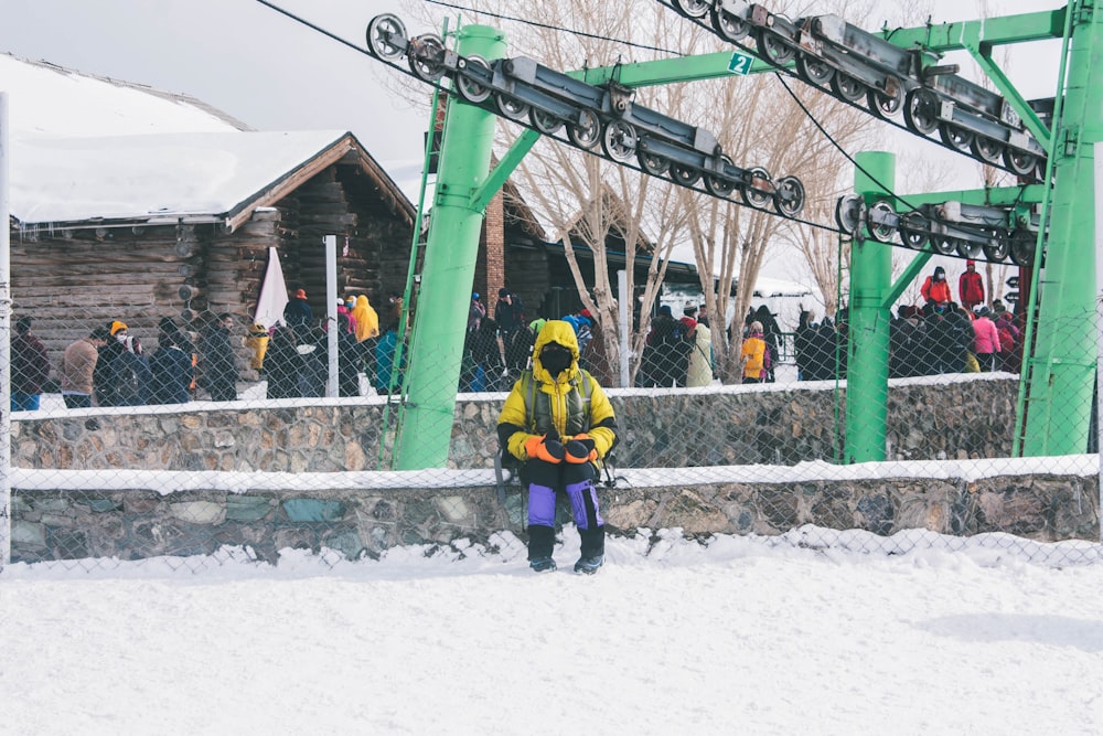 a person in a yellow jacket standing in the snow