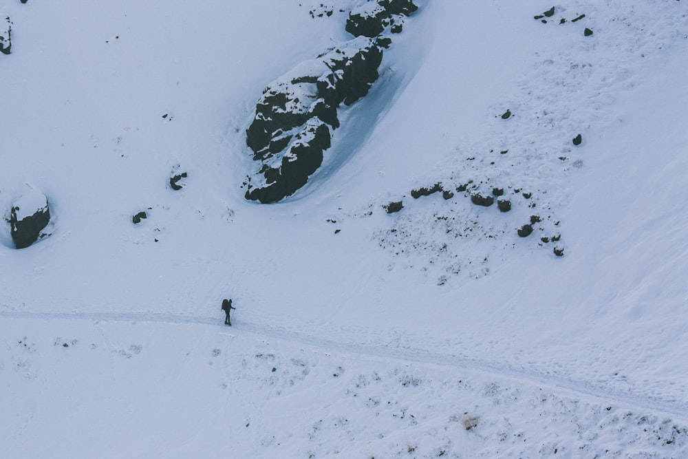 eine Luftaufnahme einer Person, die im Schnee spazieren geht