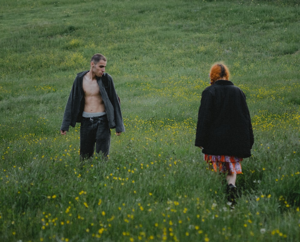 a man and a woman walking through a field