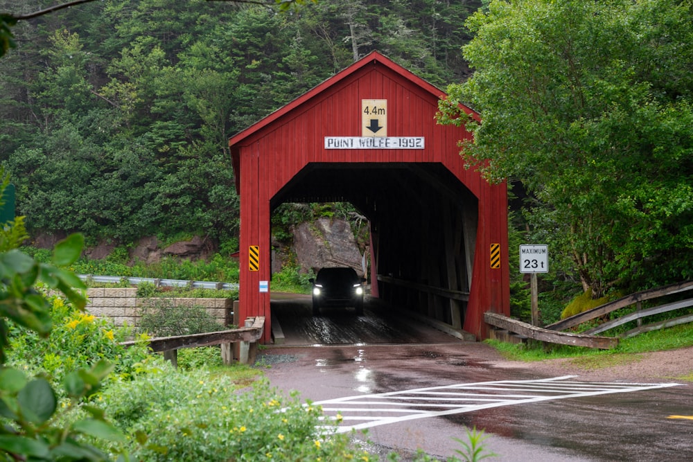 eine rote überdachte Brücke über eine nasse Straße