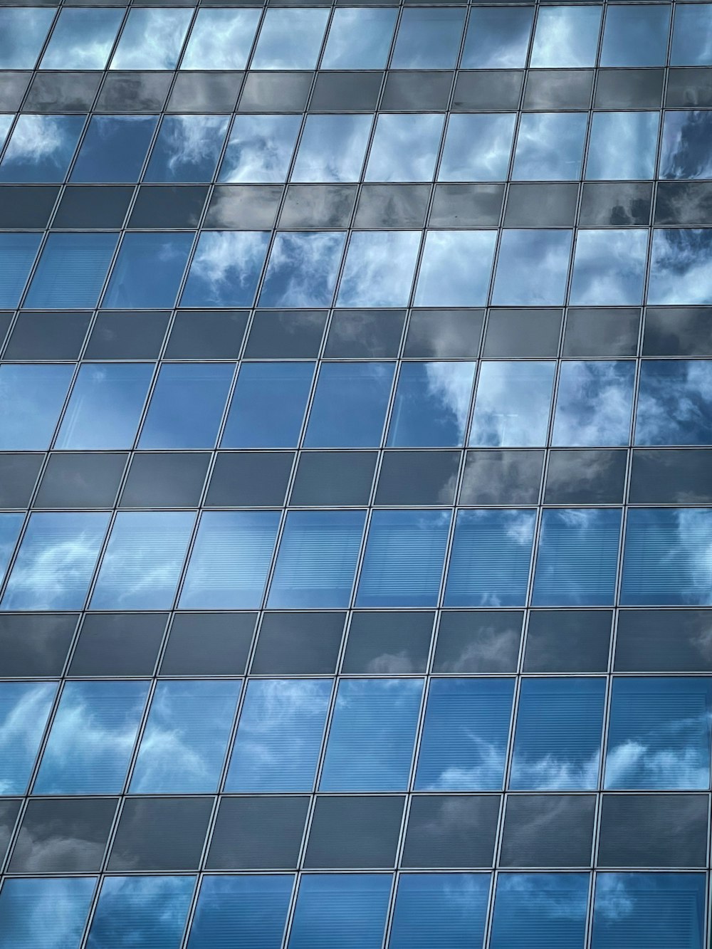 a very tall building with many windows and clouds