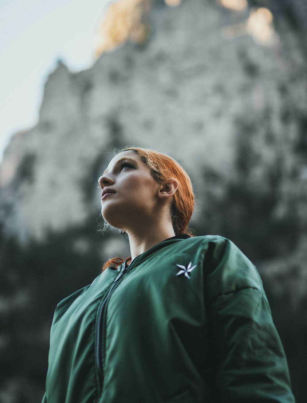 a woman with red hair wearing a green jacket