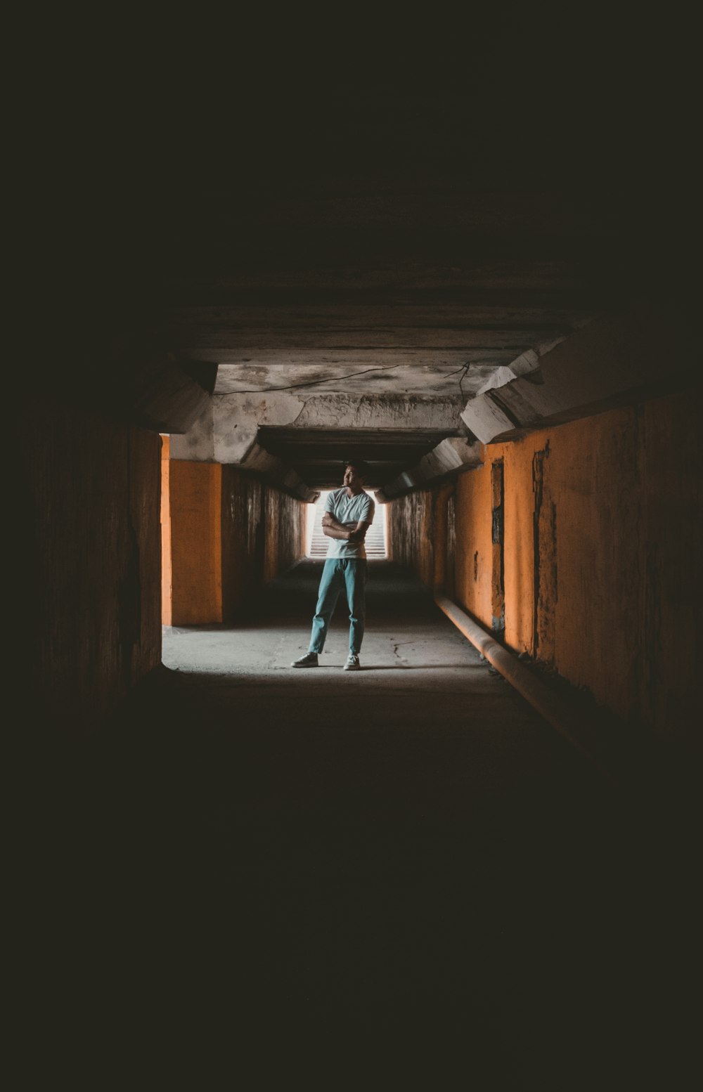 a man standing in a tunnel with his arms crossed