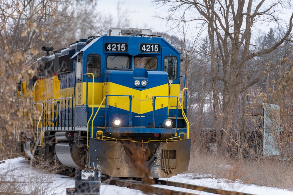 a blue and yellow train traveling down train tracks